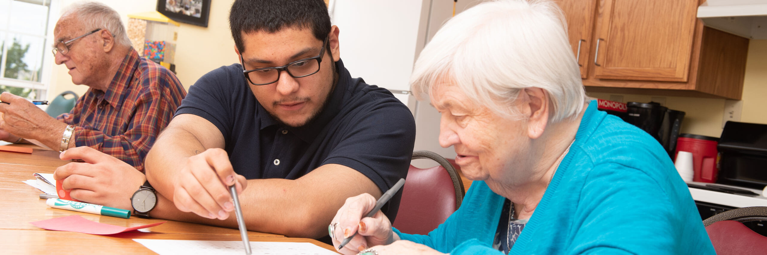 Student helps an elderly woman with paperwork.